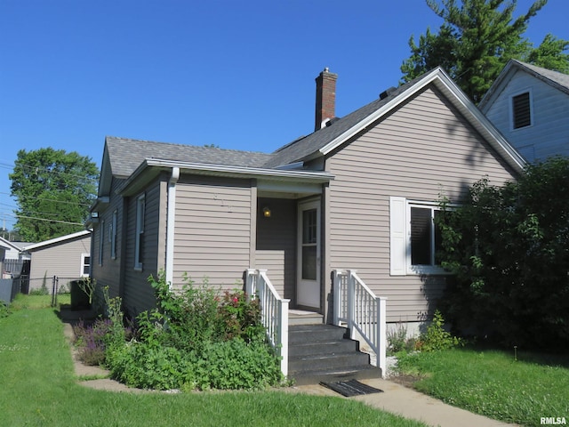312 N 3rd St, Clinton, IA 52732 - bungalow featuring a chimney and roof with shingles