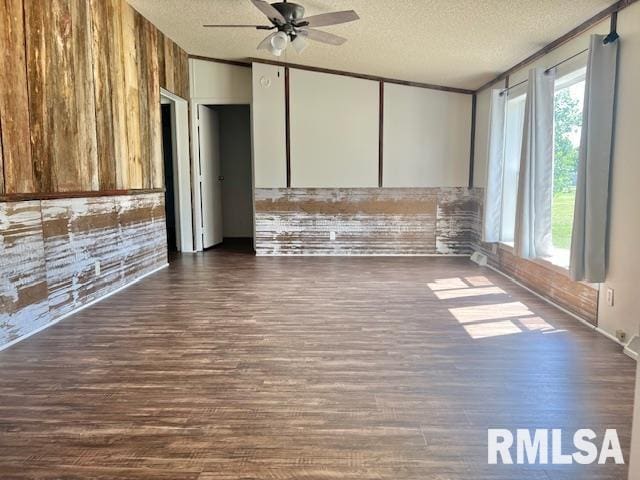 911 4th St, New Boston, IL 61272 - unfurnished living room with a textured ceiling, ceiling fan, dark wood-style flooring, and wood walls