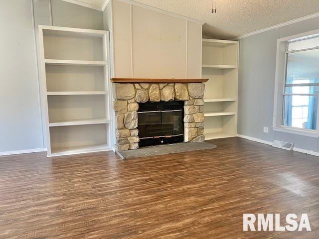 911 4th St, New Boston, IL 61272 - unfurnished living room featuring ornamental molding, dark wood-style floors, a fireplace, a textured ceiling, and built in shelves