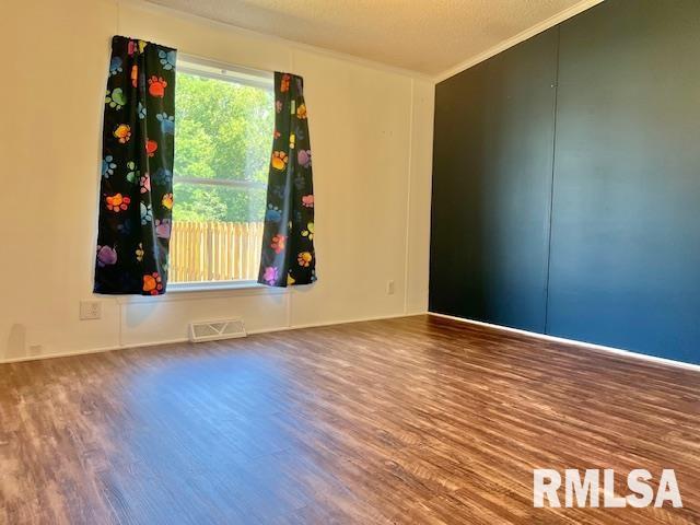911 4th St, New Boston, IL 61272 - unfurnished room featuring wood finished floors and ornamental molding