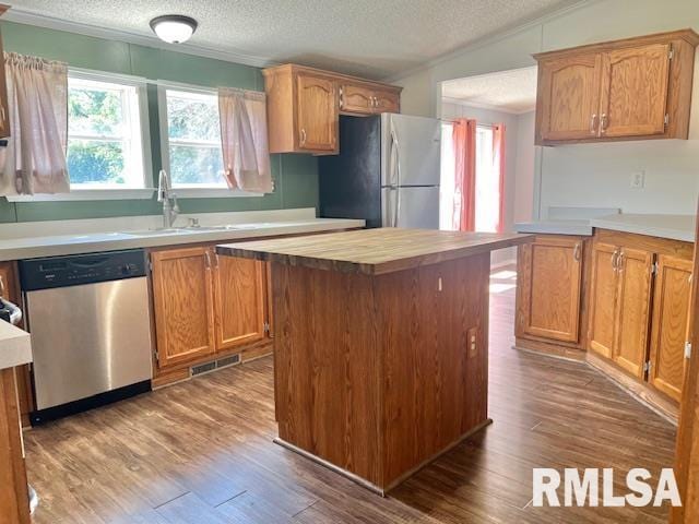 911 4th St, New Boston, IL 61272 - kitchen featuring appliances with stainless steel finishes, crown molding, a textured ceiling, wood finished floors, and a kitchen island