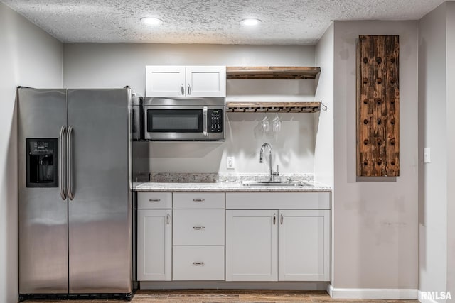 4932 Torrey Pines Ct, Davenport, IA 52807 - kitchen featuring stainless steel appliances, open shelves, light stone countertops, a textured ceiling, and recessed lighting