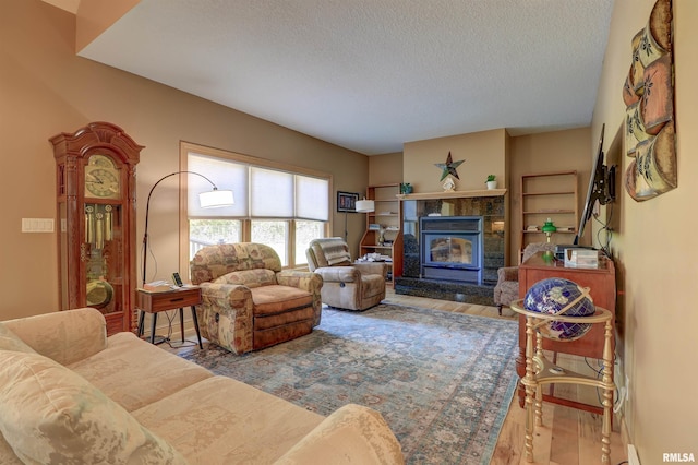 4581 180th St, Clinton, IA 52732 - living room featuring a textured ceiling, wood finished floors, and a stone fireplace