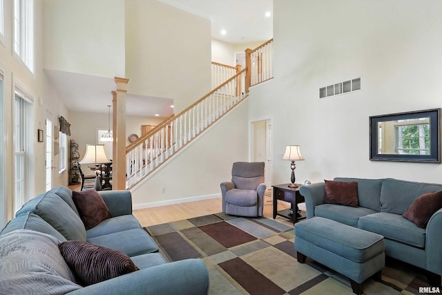 905 Bridgeview Place, Le Claire, IA 52753 - living area featuring a towering ceiling, plenty of natural light, wood finished floors, stairs, and recessed lighting