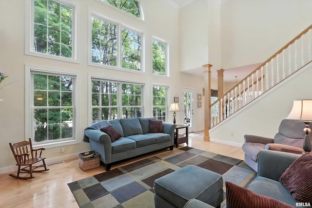 905 Bridgeview Place, Le Claire, IA 52753 - living room featuring wood finished floors, healthy amount of natural light, a high ceiling, and stairs