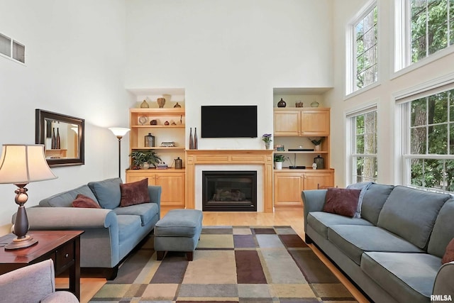 905 Bridgeview Place, Le Claire, IA 52753 - living room with a towering ceiling, a glass covered fireplace, dark wood-type flooring, and built in shelves