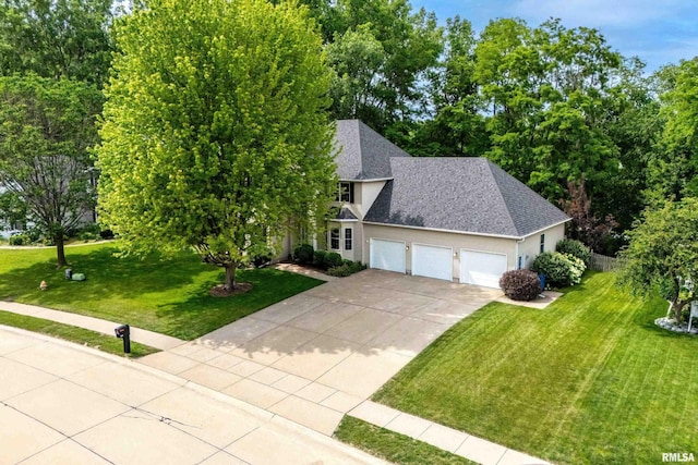 905 Bridgeview Place, Le Claire, IA 52753 - view of front of property featuring a garage, a front yard, concrete driveway, a shingled roof, and stucco siding