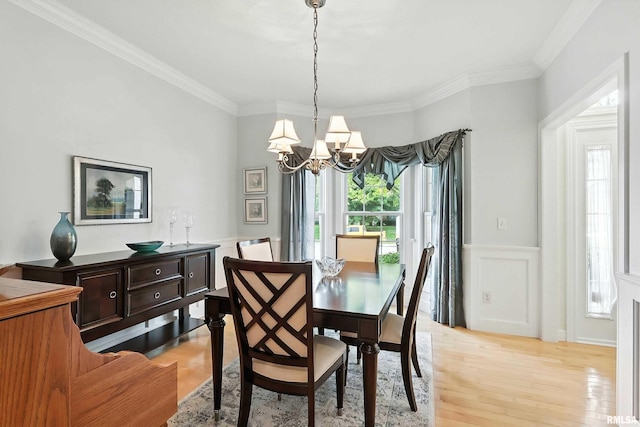 905 Bridgeview Place, Le Claire, IA 52753 - dining room featuring healthy amount of natural light, a chandelier, ornamental molding, a wainscoted wall, and light wood-style floors
