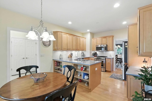 905 Bridgeview Place, Le Claire, IA 52753 - kitchen featuring stainless steel appliances, light brown cabinetry, tasteful backsplash, light wood-style flooring, and a chandelier