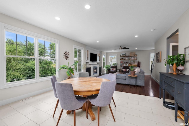 5727 Charlie Chase Ln, Bettendorf, IA 52722 - dining area with a glass covered fireplace, recessed lighting, a ceiling fan, and light tile patterned flooring