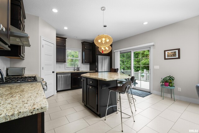 5727 Charlie Chase Ln, Bettendorf, IA 52722 - kitchen with appliances with stainless steel finishes, a breakfast bar, recessed lighting, a kitchen island, and pendant lighting