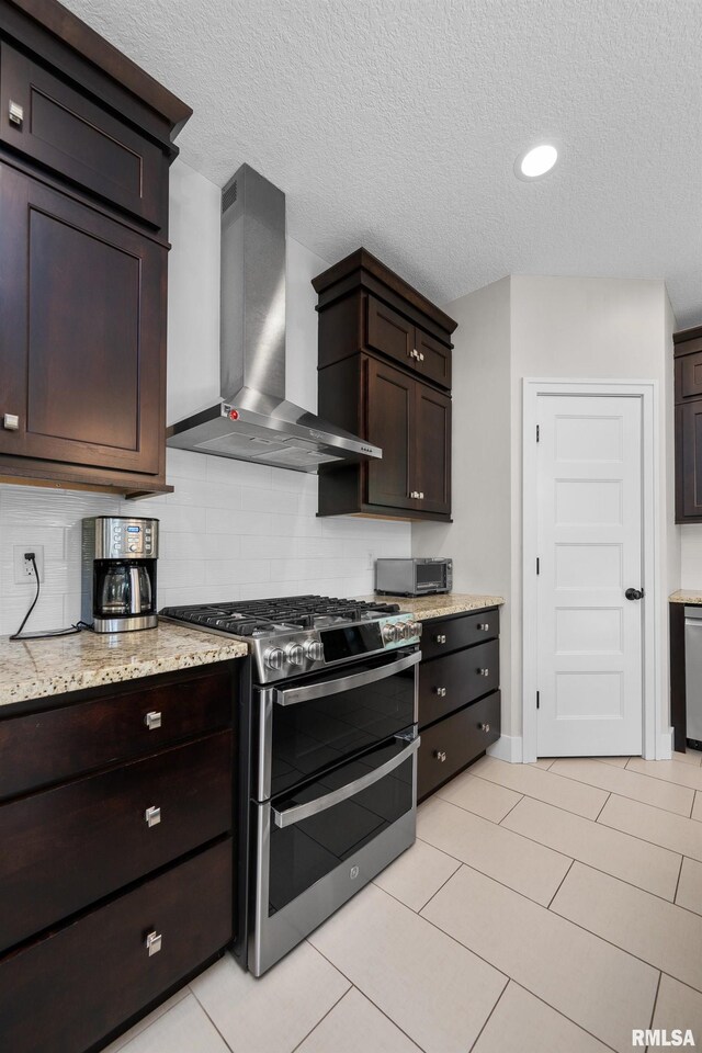 5727 Charlie Chase Ln, Bettendorf, IA 52722 - kitchen with wall chimney range hood, double oven range, backsplash, dark brown cabinets, and a textured ceiling