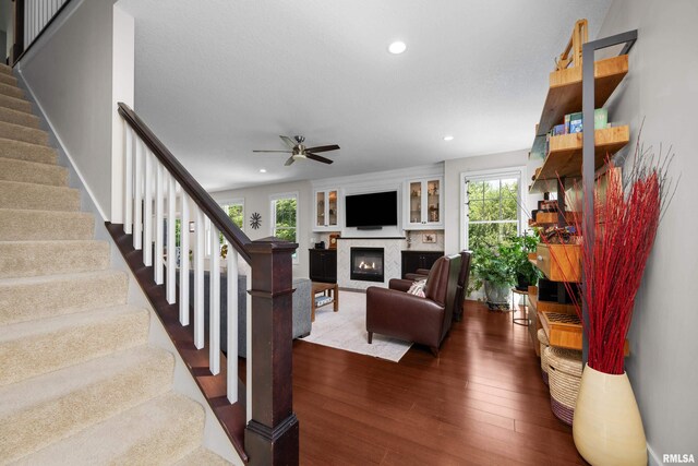 5727 Charlie Chase Ln, Bettendorf, IA 52722 - living room featuring a glass covered fireplace, dark wood-style flooring, healthy amount of natural light, stairway, and recessed lighting
