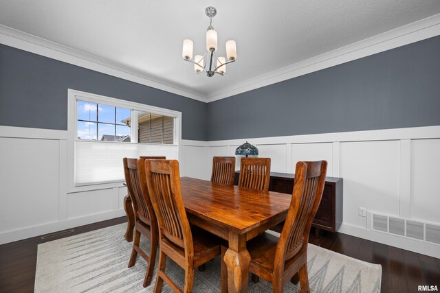 5727 Charlie Chase Ln, Bettendorf, IA 52722 - dining space with a chandelier, a wainscoted wall, hardwood / wood-style floors, ornamental molding, and a decorative wall