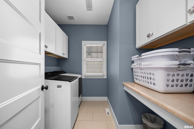 5727 Charlie Chase Ln, Bettendorf, IA 52722 - laundry room with washing machine and clothes dryer, cabinet space, light tile patterned flooring, and a textured ceiling