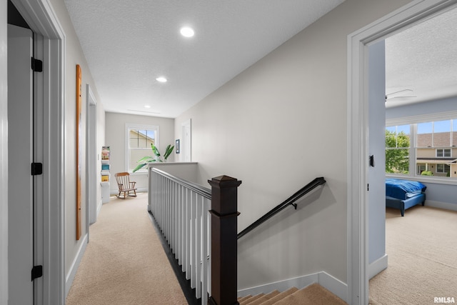 5727 Charlie Chase Ln, Bettendorf, IA 52722 - hall featuring an upstairs landing, light colored carpet, a textured ceiling, recessed lighting, and healthy amount of natural light