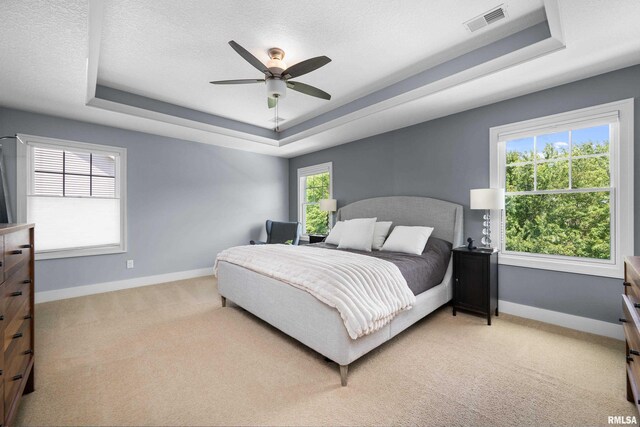 5727 Charlie Chase Ln, Bettendorf, IA 52722 - bedroom with a raised ceiling, light carpet, and ceiling fan