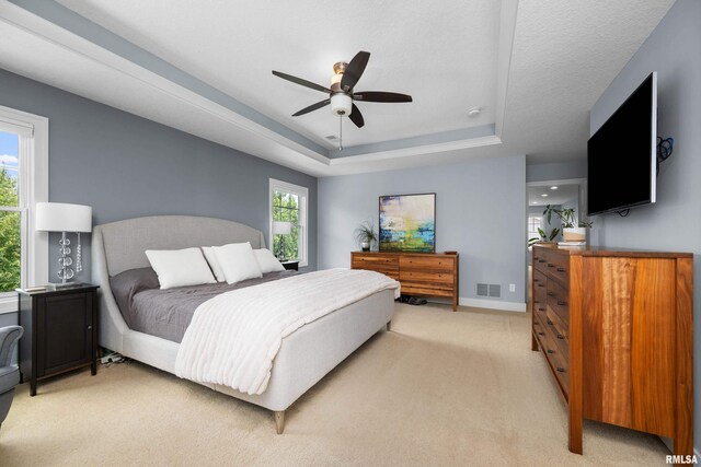 5727 Charlie Chase Ln, Bettendorf, IA 52722 - bedroom with light colored carpet, a tray ceiling, and ceiling fan