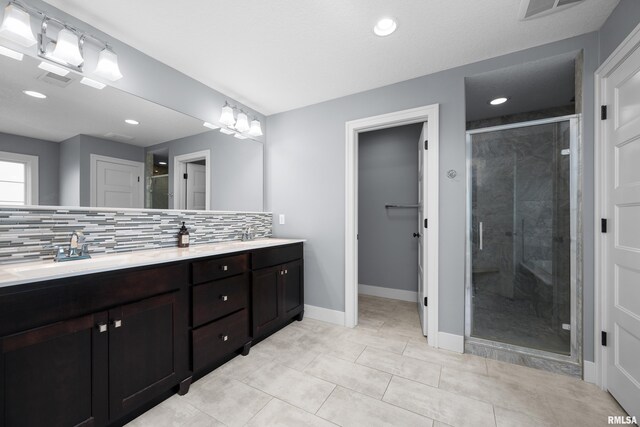 5727 Charlie Chase Ln, Bettendorf, IA 52722 - full bath featuring double vanity, decorative backsplash, a shower stall, recessed lighting, and tile patterned floors