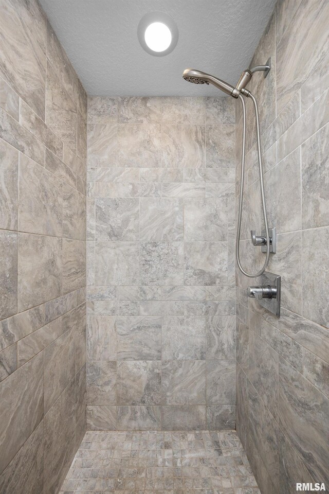 5727 Charlie Chase Ln, Bettendorf, IA 52722 - full bathroom featuring a tile shower and a textured ceiling