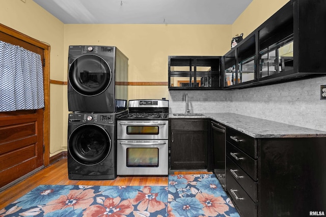 1632 18th Ave Unit 6, Rock Island, IL 61201 - kitchen with dark cabinetry, stacked washer / dryer, appliances with stainless steel finishes, light wood finished floors, and backsplash