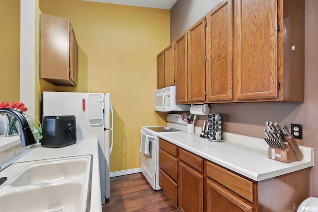 4011 Lillie Ave Unit 106, Davenport, IA 52806 - kitchen featuring white appliances, light countertops, dark wood-style floors, and brown cabinetry