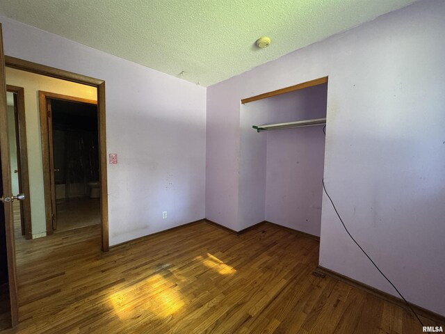 2938 Summit Hills Ct, Bettendorf, IA 52722 - unfurnished bedroom featuring wood finished floors, a closet, and a textured ceiling