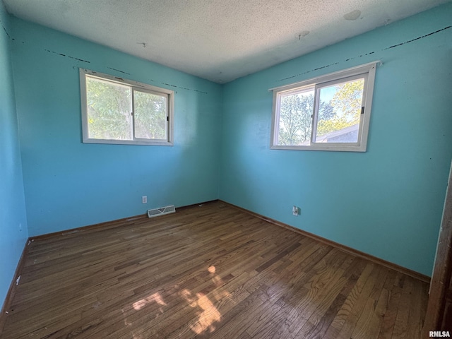 2938 Summit Hills Ct, Bettendorf, IA 52722 - unfurnished room featuring wood finished floors, a textured ceiling, and healthy amount of natural light