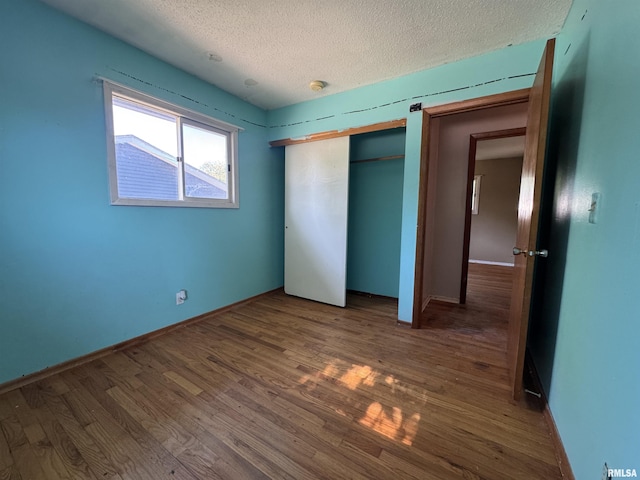 2938 Summit Hills Ct, Bettendorf, IA 52722 - unfurnished bedroom with a textured ceiling, dark wood-style floors, and a closet