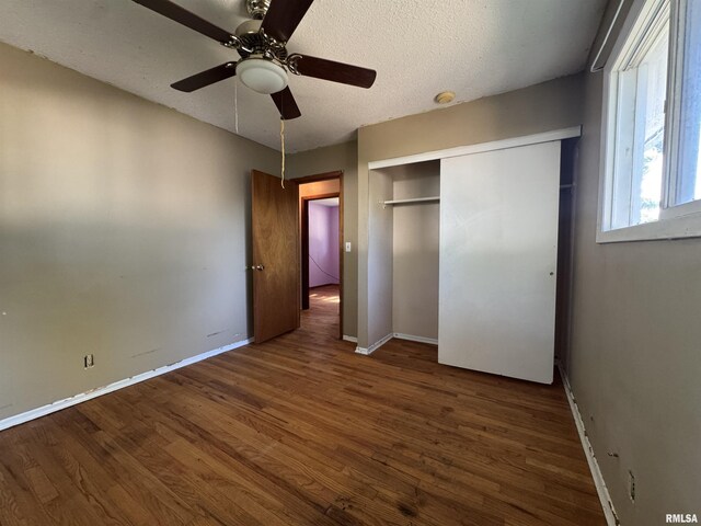 2938 Summit Hills Ct, Bettendorf, IA 52722 - unfurnished bedroom with wood finished floors, a closet, a textured ceiling, and ceiling fan