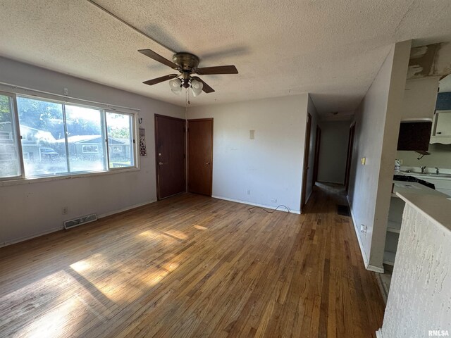 2938 Summit Hills Ct, Bettendorf, IA 52722 - empty room featuring a textured ceiling, a ceiling fan, and wood finished floors