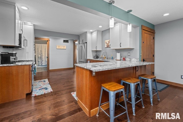 11815 Rte 84 N, Port Byron, IL 61275 - kitchen featuring stainless steel appliances, a peninsula, dark wood-type flooring, light stone counters, and white cabinetry