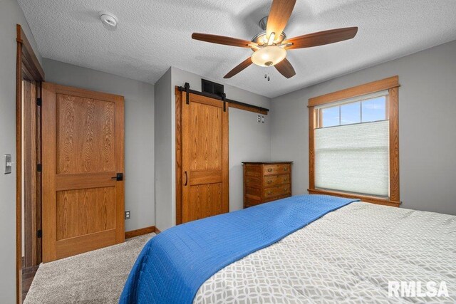 11815 Rte 84 N, Port Byron, IL 61275 - bedroom featuring a barn door, a textured ceiling, carpet floors, and ceiling fan