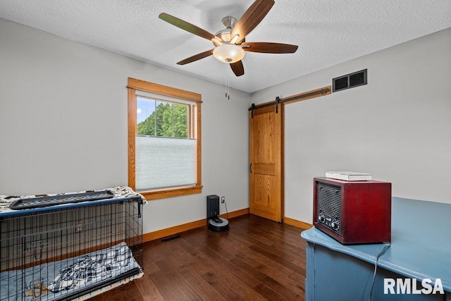 11815 Rte 84 N, Port Byron, IL 61275 - bedroom with wood finished floors, a barn door, a textured ceiling, and ceiling fan