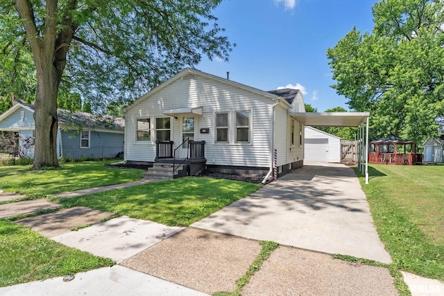 209 45th St, Moline, IL 61265 - view of front of house featuring an outdoor structure, driveway, a front lawn, and a carport