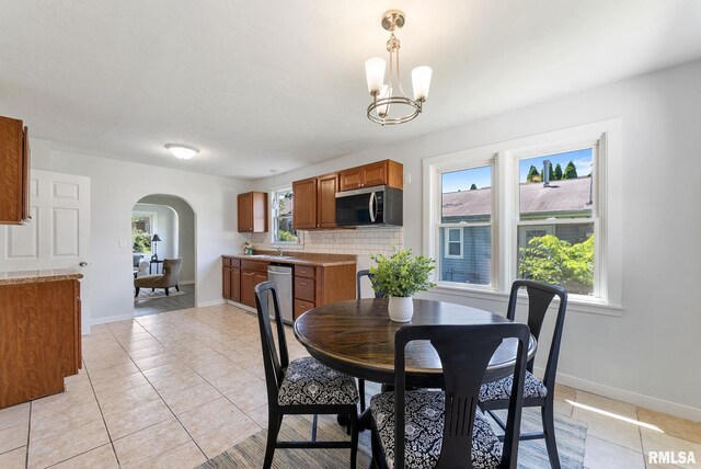 209 45th St, Moline, IL 61265 - dining area with arched walkways, a chandelier, and light tile patterned flooring