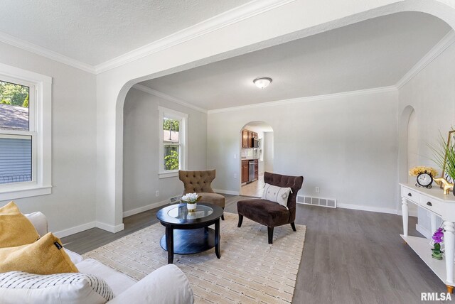 209 45th St, Moline, IL 61265 - living area with arched walkways, wood finished floors, and ornamental molding