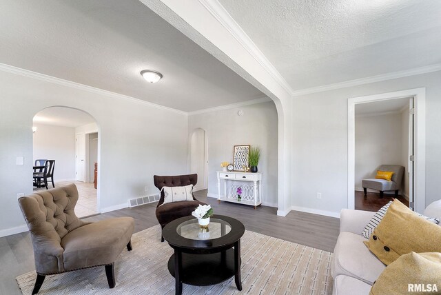 209 45th St, Moline, IL 61265 - living area with arched walkways, wood finished floors, ornamental molding, and a textured ceiling