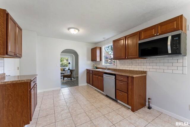 209 45th St, Moline, IL 61265 - kitchen with appliances with stainless steel finishes, arched walkways, healthy amount of natural light, and decorative backsplash