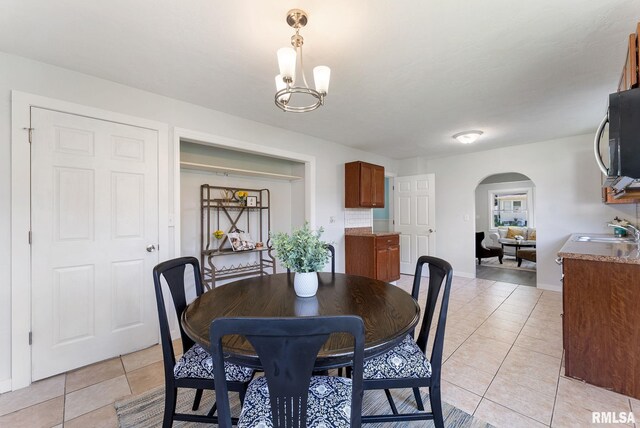 209 45th St, Moline, IL 61265 - dining area with arched walkways, light tile patterned flooring, and a chandelier