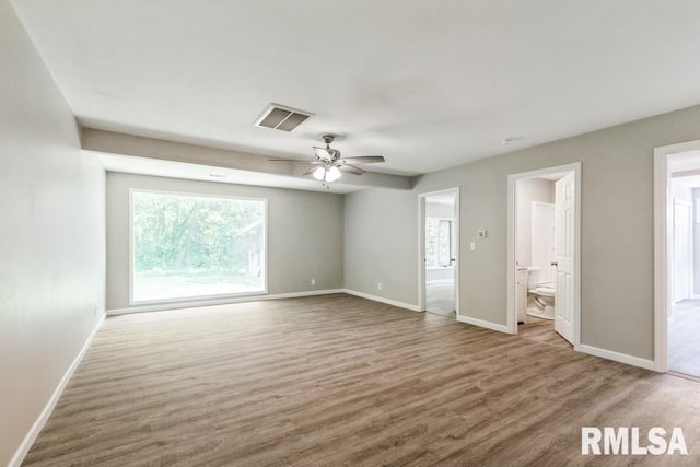 1231 Devils Glen Rd, Bettendorf, IA 52722 - unfurnished bedroom featuring multiple windows, wood finished floors, and connected bathroom