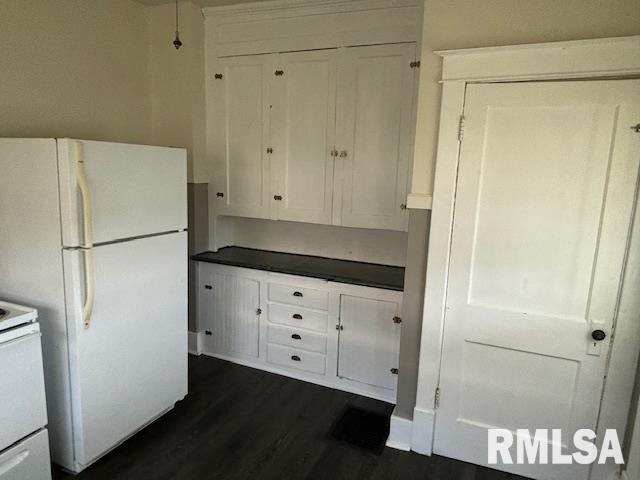 712 Roosevelt Ave, Kewanee, IL 61443 - kitchen with white appliances, white cabinets, dark countertops, and dark wood finished floors