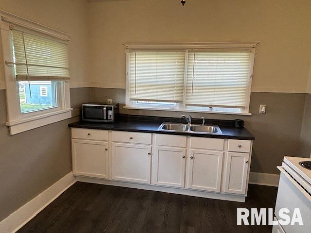 712 Roosevelt Ave, Kewanee, IL 61443 - kitchen featuring stainless steel microwave, dark wood-style flooring, dark countertops, white cabinets, and white electric range oven