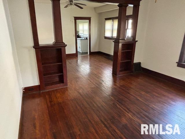 712 Roosevelt Ave, Kewanee, IL 61443 - spare room featuring dark wood finished floors, ornate columns, and a ceiling fan