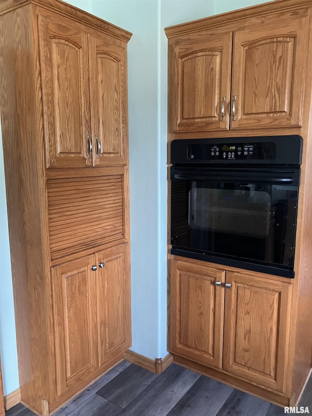 114 S State St, Annawan, IL 61234 - kitchen featuring black oven, wood finished floors, and brown cabinets