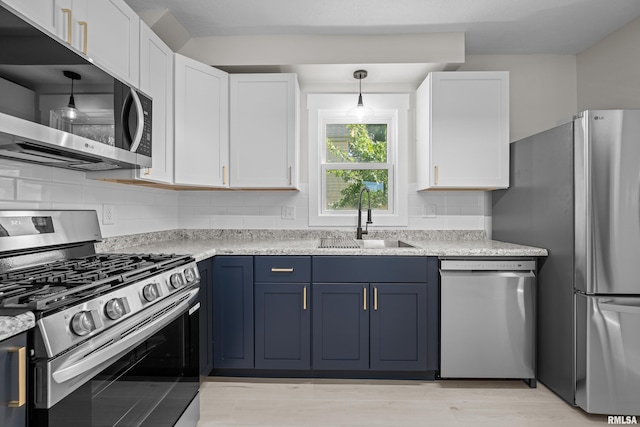 2664 Fair Ave, Davenport, IA 52803 - kitchen with appliances with stainless steel finishes, white cabinetry, blue cabinets, tasteful backsplash, and light countertops