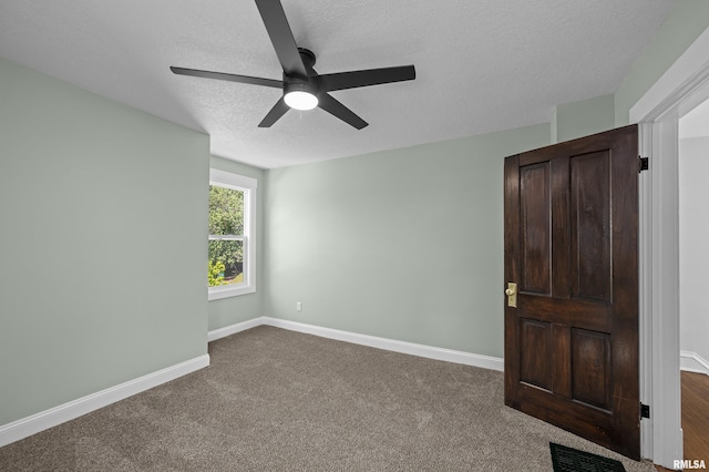 2664 Fair Ave, Davenport, IA 52803 - unfurnished bedroom featuring a textured ceiling, dark carpet, and ceiling fan