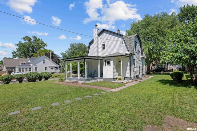 2664 Fair Ave, Davenport, IA 52803 - rear view of property with a gambrel roof, a lawn, a chimney, and a patio