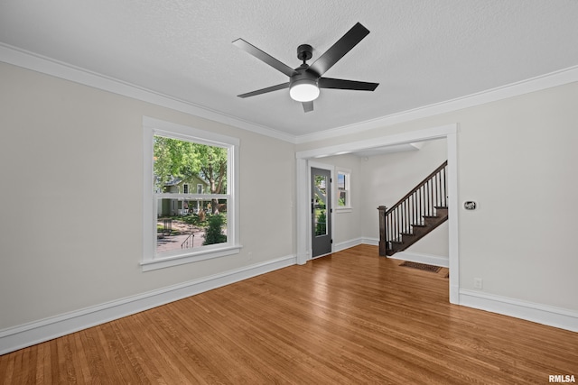 2664 Fair Ave, Davenport, IA 52803 - spare room featuring stairway, wood finished floors, a textured ceiling, ornamental molding, and ceiling fan