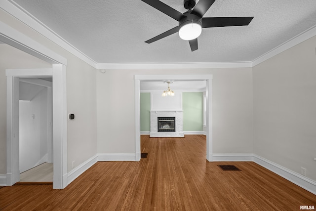 2664 Fair Ave, Davenport, IA 52803 - unfurnished living room with wood finished floors, a textured ceiling, ceiling fan, a fireplace, and a chandelier